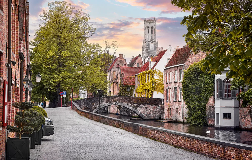 Canal de Bruges, pont de pierre et façades de briques avec le beffroi en arrière-plan — Bruxelles