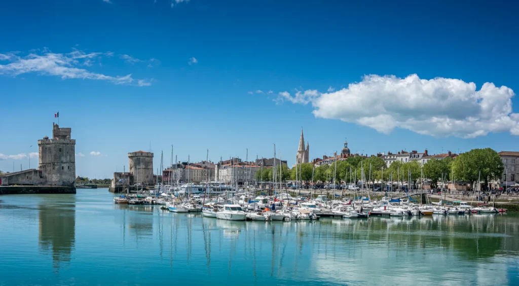 Panorama du Vieux-Port de La Rochelle : tours médiévales, voiliers au mouillage et quais animés