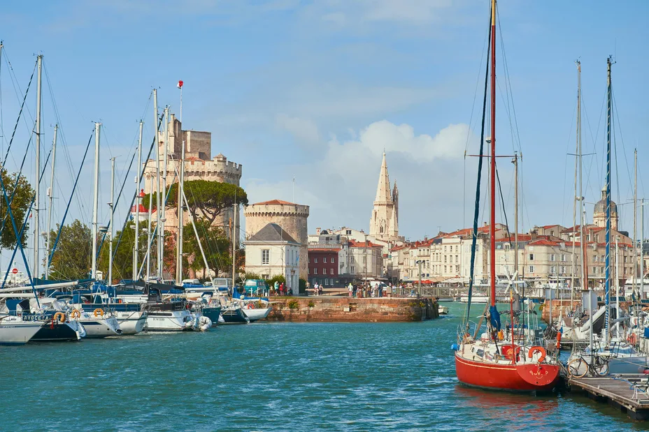 Le Vieux-Port de La Rochelle avec ses voiliers, dont un élégant monocoque rouge, au pied des tours