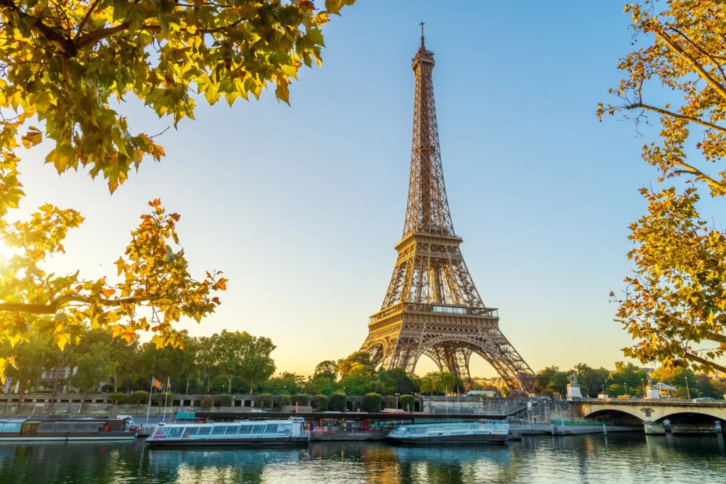 La Tour Eiffel au bord de la Seine, avec bateaux-mouches à quai au soleil levant — Paris