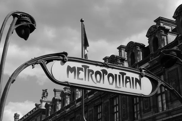 Enseigne Art nouveau « Métropolitain » en noir et blanc, façades haussmanniennes en toile de fond — Paris