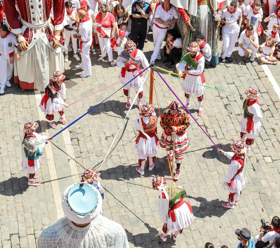 Danseurs traditionnels en tenue de fête, rubans et foule en blanc et rouge lors d'une feria — Pau